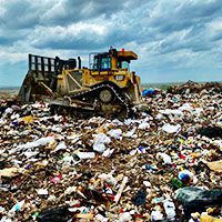 Bulldozer clearing a landfill of trash