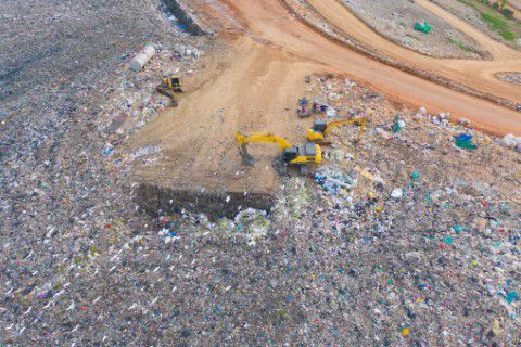 Excavator cleaning up a landfill site