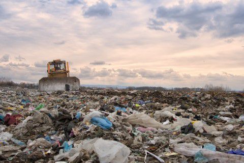 Photo of a garbage dump with a bulldozer clearing it